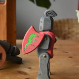 Ostheimer black riding knight handmade wooden toy figure with shield and long sword placed on a wooden surface.