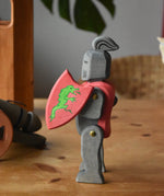 Ostheimer black riding knight handmade wooden toy figure with shield and long sword placed on a wooden surface.