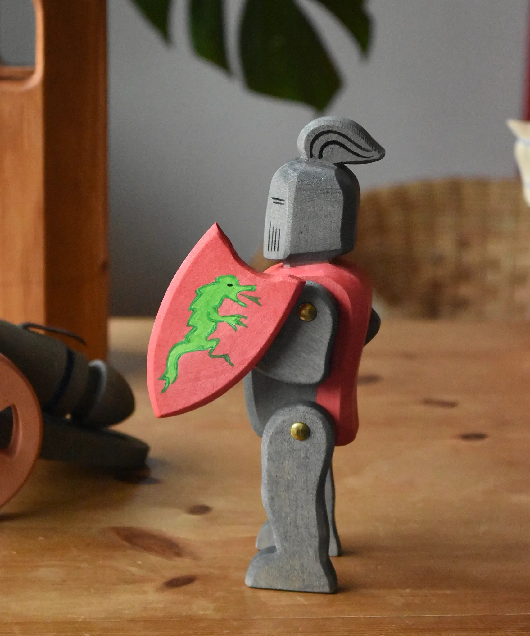 Ostheimer black riding knight handmade wooden toy figure with shield and long sword placed on a wooden surface.