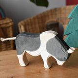 Ostheimer black and white ox wooden toy figure placed on a wooden surface in the Babipur playroom.