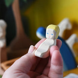 Baby Jesus from the Ostheimer wooden toy nativity set in an adult's hand.