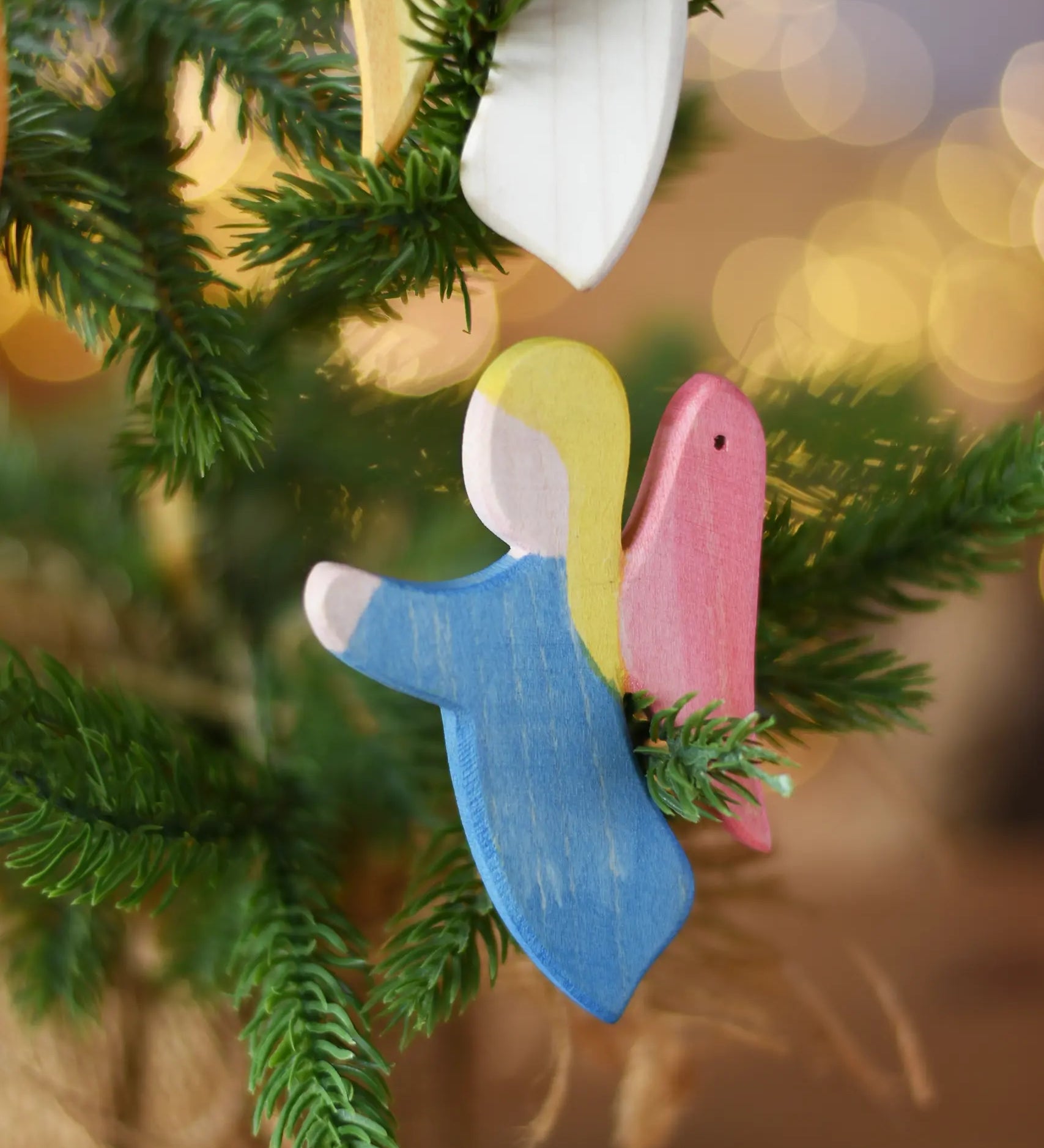 Ostheimer blue angel wooden handmade decoration placed on a Christmas tree branch. 