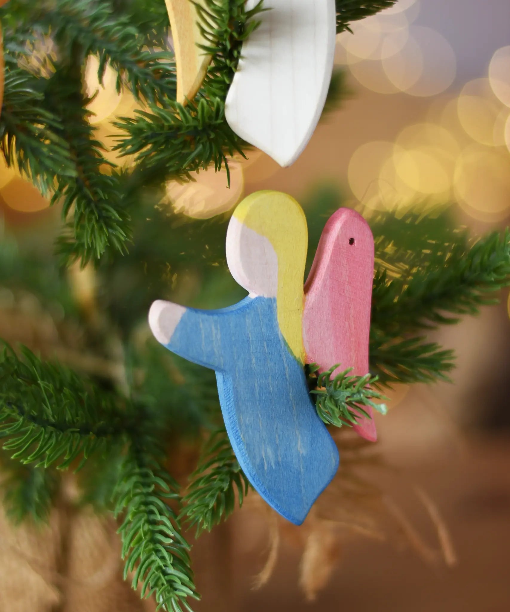 Ostheimer blue angel wooden handmade decoration placed on a Christmas tree branch. 