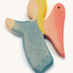 A blue wooden angel figure on a cream background.