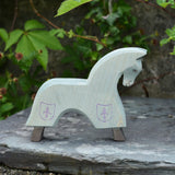 The Ostheimer blue horse toy figure placed on a slate surface outdoors.