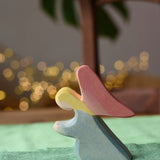 Ostheimer blue kneeling angel wooden toy figure placed on a green cotton play cloth.