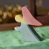 Ostheimer blue kneeling angel wooden toy figure placed on a green cotton play cloth.