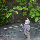 Ostheimer blue riding wooden knight placed on a slate surface outdoors.