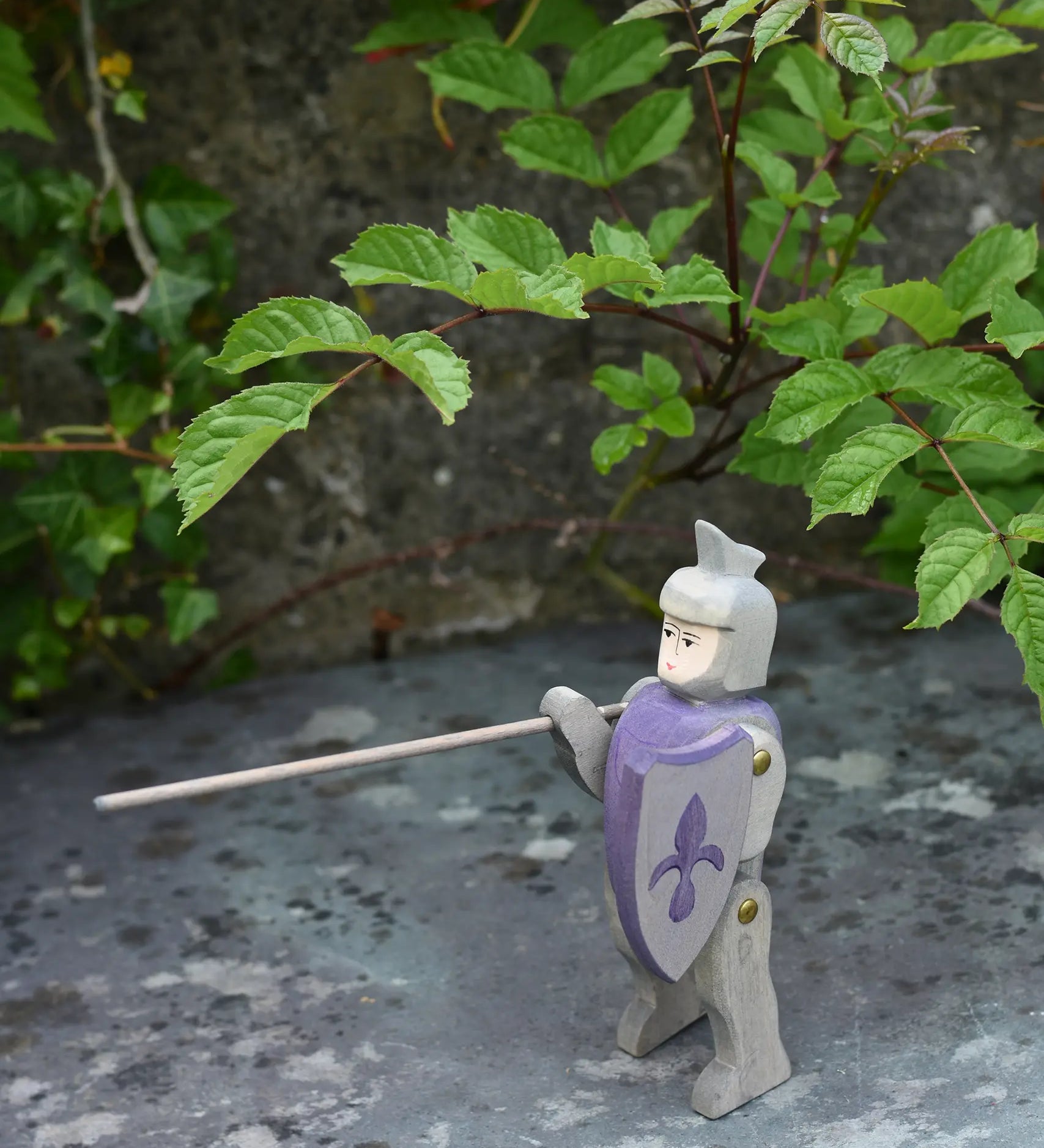 Ostheimer blue riding wooden knight placed on a slate surface outdoors.