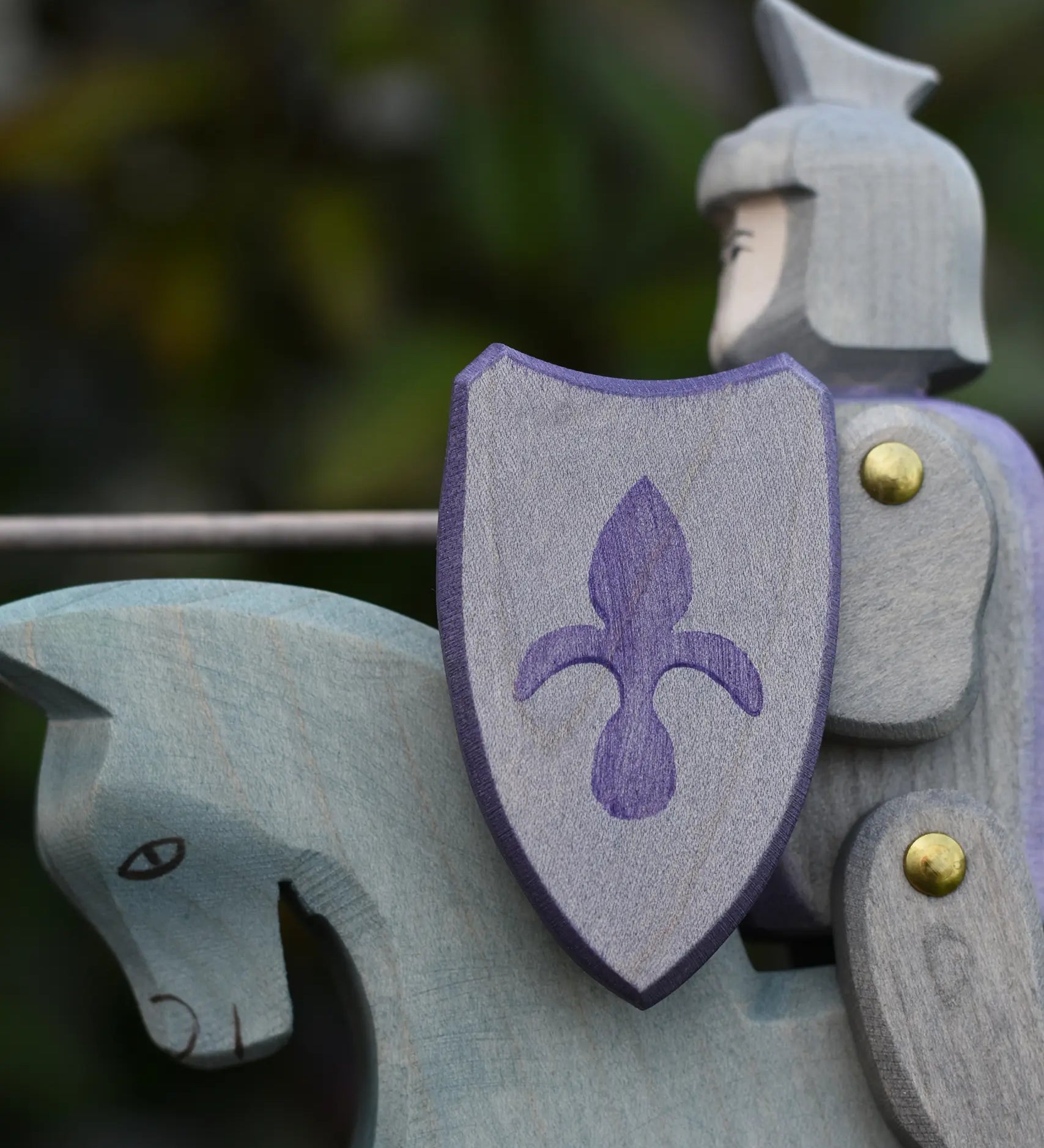 Close up of the shield on the Ostheimer blue riding wooden knight on a grey horse toy figure.