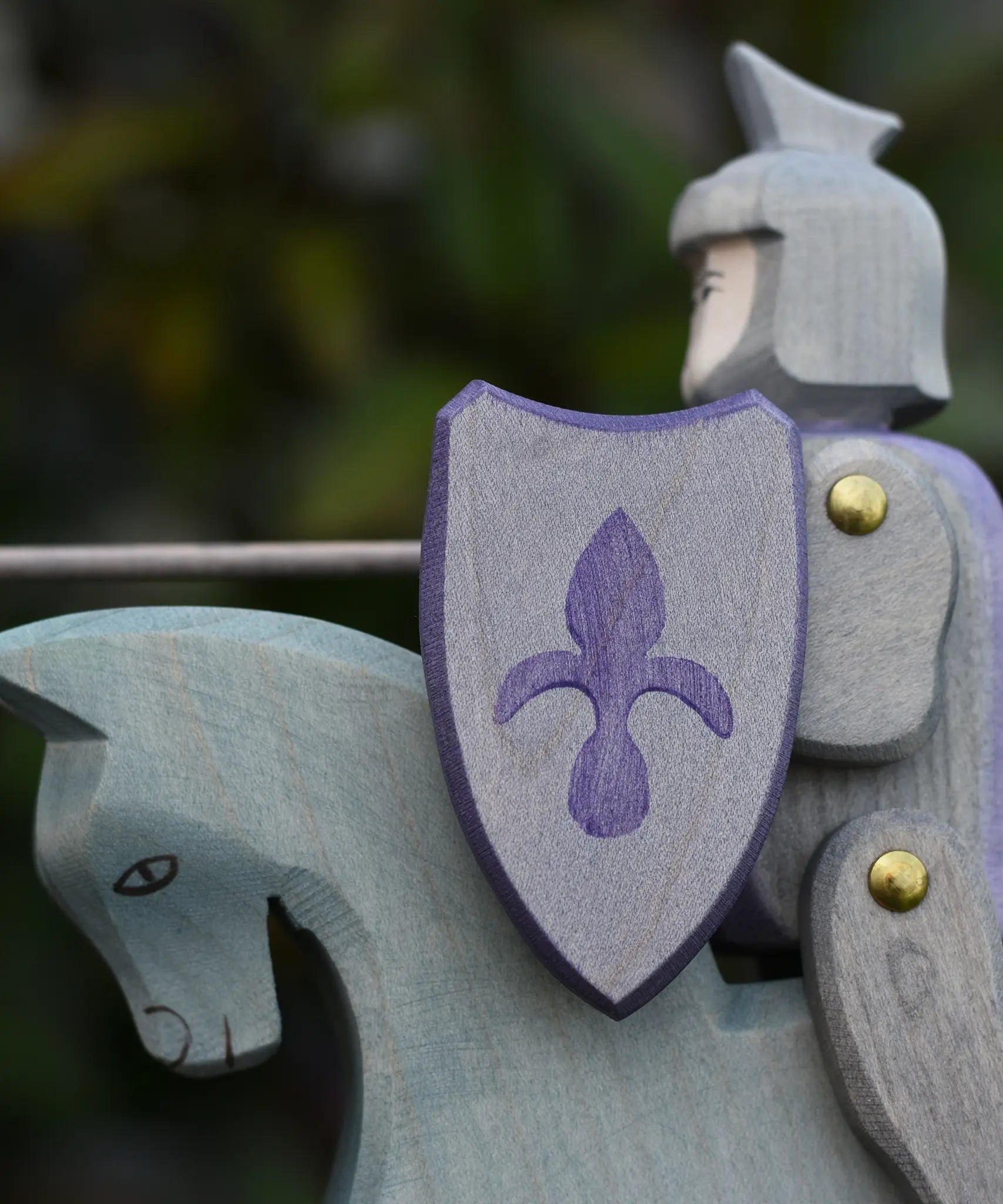 Close up of the shield on the Ostheimer blue riding wooden knight on a grey horse toy figure.