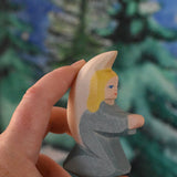 A turquoise blue coloured Ostheimer little angel held in an adult's hand to show scale. This wooden figure is part of a large range of expertly hand crafted, Waldorf inspired, wooden toys here at Babipur. 
