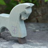 The Ostheimer blue horse toy figure placed on a slate surface outdoors.