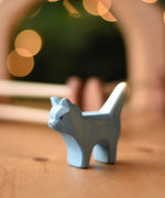 An Ostheimer Bremer cat wooden toy figure placed on a wooden surface.  Ostheimer's range of hand crafted, heirloom quality wooden toys are available to buy at Babipur. 