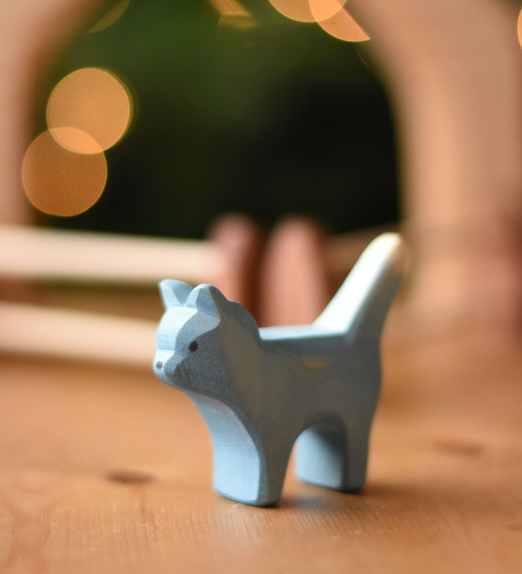 An Ostheimer Bremer cat wooden toy figure placed on a wooden surface.  Ostheimer's range of hand crafted, heirloom quality wooden toys are available to buy at Babipur. 