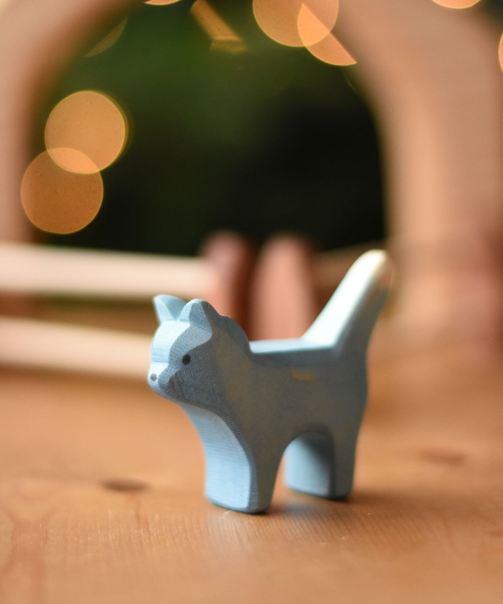 An Ostheimer Bremer cat wooden toy figure placed on a wooden surface.  Ostheimer's range of hand crafted, heirloom quality wooden toys are available to buy at Babipur. 