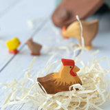 Ostheimer Brown Hen on Nest figure pictured on wood wool nest. Other Ostheimer figures can be seen in the background. 
