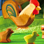 A brown Ostheimer rooster pictured in a small world play set up with small brown and yellow chicks on a green felt surface. 