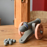 Back of the Ostheimer cannon wooden toy with 10 wooden balls placed on a wooden surface.