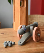Back of the Ostheimer cannon wooden toy with 10 wooden balls placed on a wooden surface.