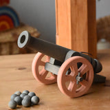Ostheimer cannon wooden toy with 10 wooden balls placed on a wooden surface.