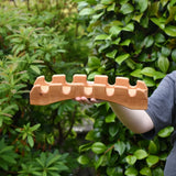 Ostheimer handmade wooden castle bridge toy in a child's hand.