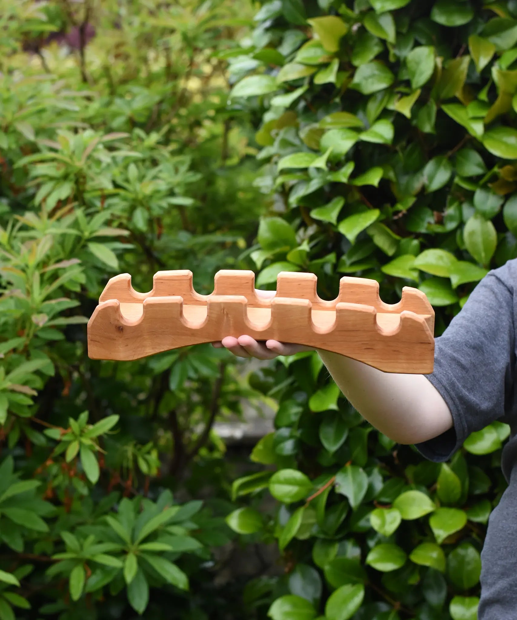 Ostheimer handmade wooden castle bridge toy in a child's hand.