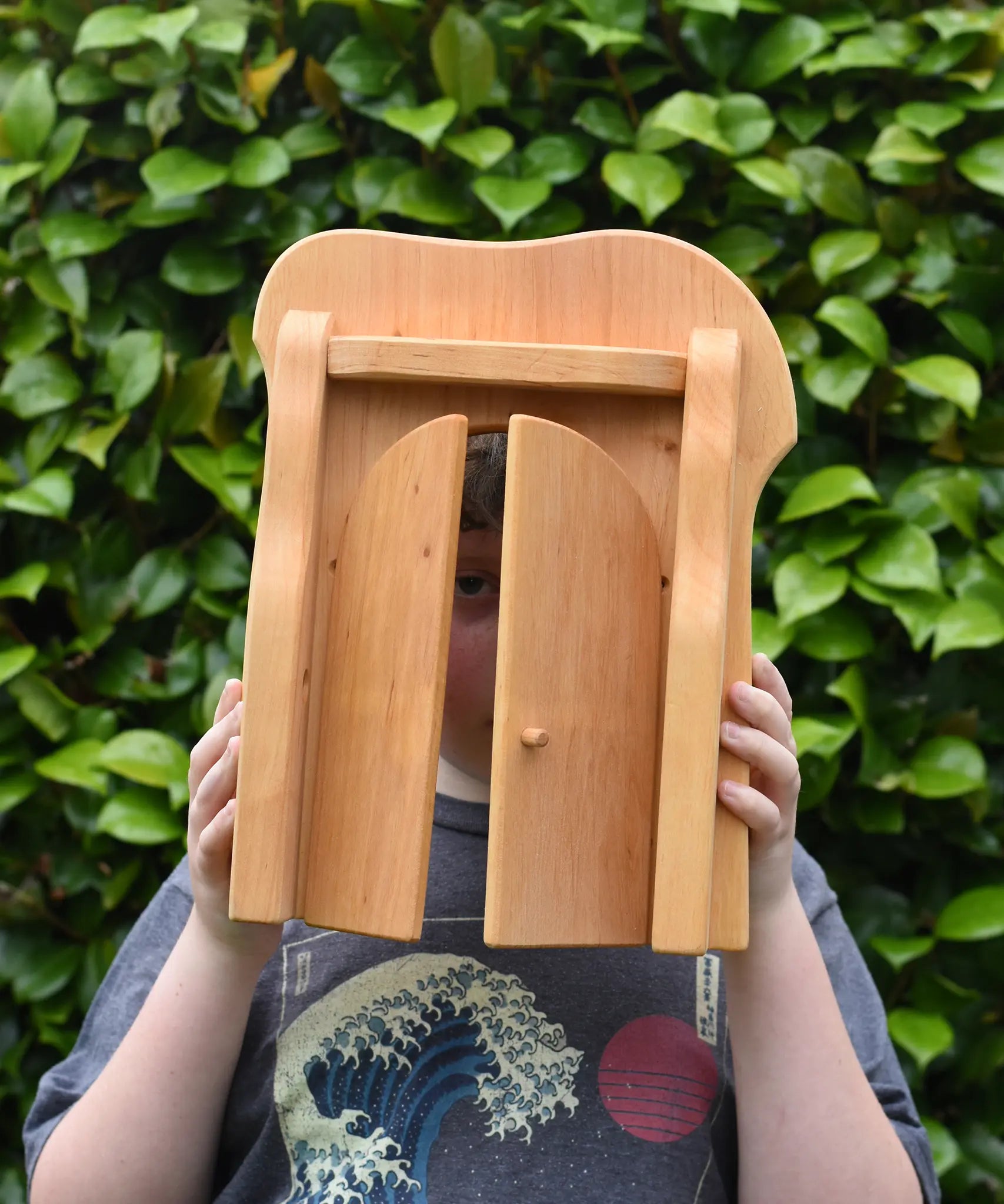Ostheimer castle gate in a child's hands with locking bar taken off and child peering through.