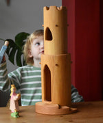 Ostheimer castle round tower with stairs wooden toy building with a child standing behind looking up at the top of the tower.