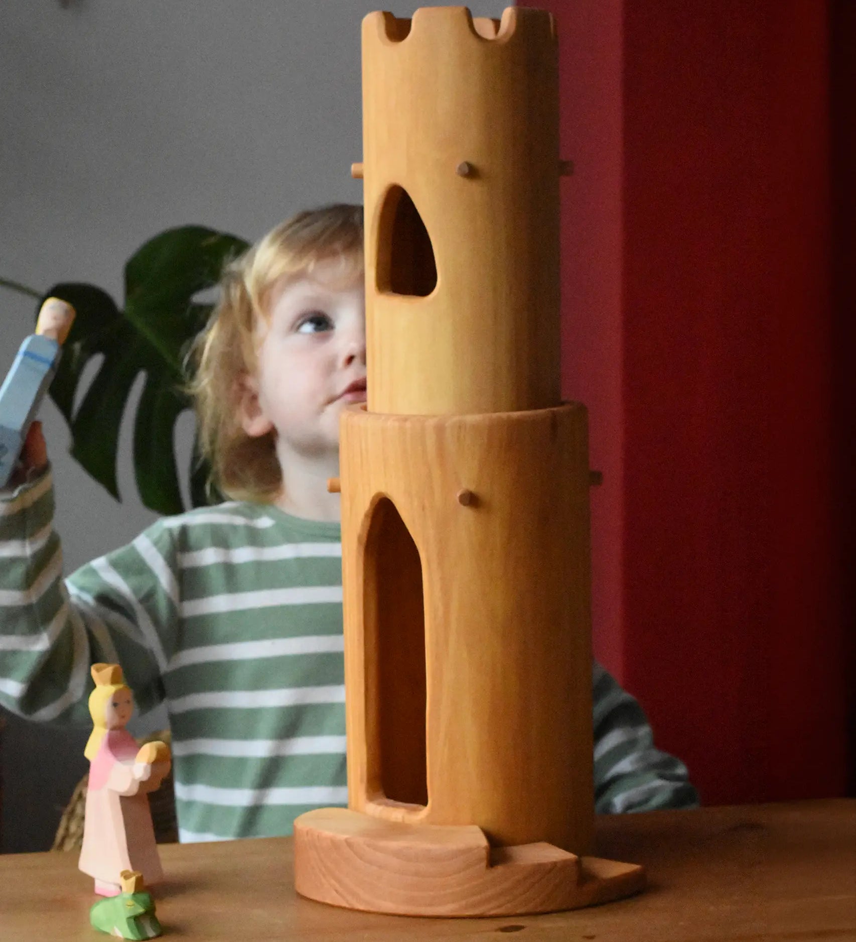 Ostheimer castle round tower with stairs wooden toy building with a child standing behind looking up at the top of the tower.