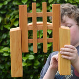 Ostheimer wooden castle trellised gate in a child's hands with the gate open.
