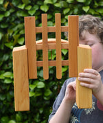 Ostheimer wooden castle trellised gate in a child's hands with the gate open.