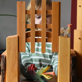 Ostheimer wooden castle trellised gate with a child placing a dragon underneath the open gate.