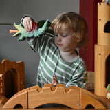 Ostheimer castle and wharf set placed at the front of a small world play set up with a child behind holding a dragon figure.