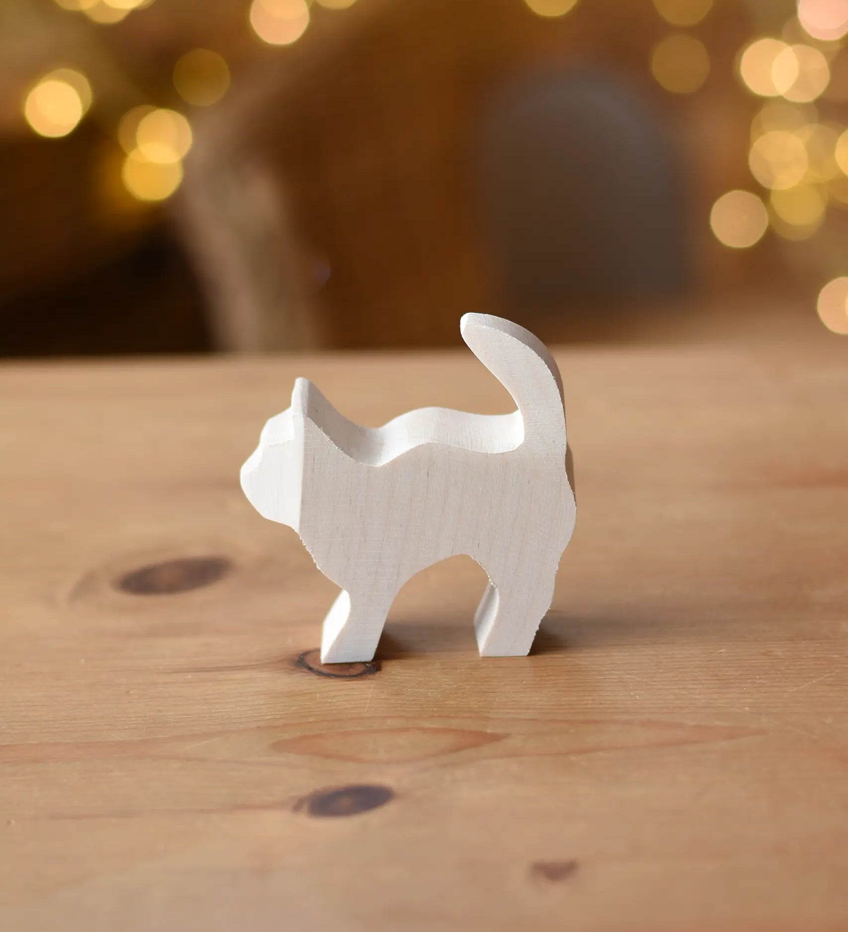 Ostheimer paint your own standing cat figure placed on a wooden surface.