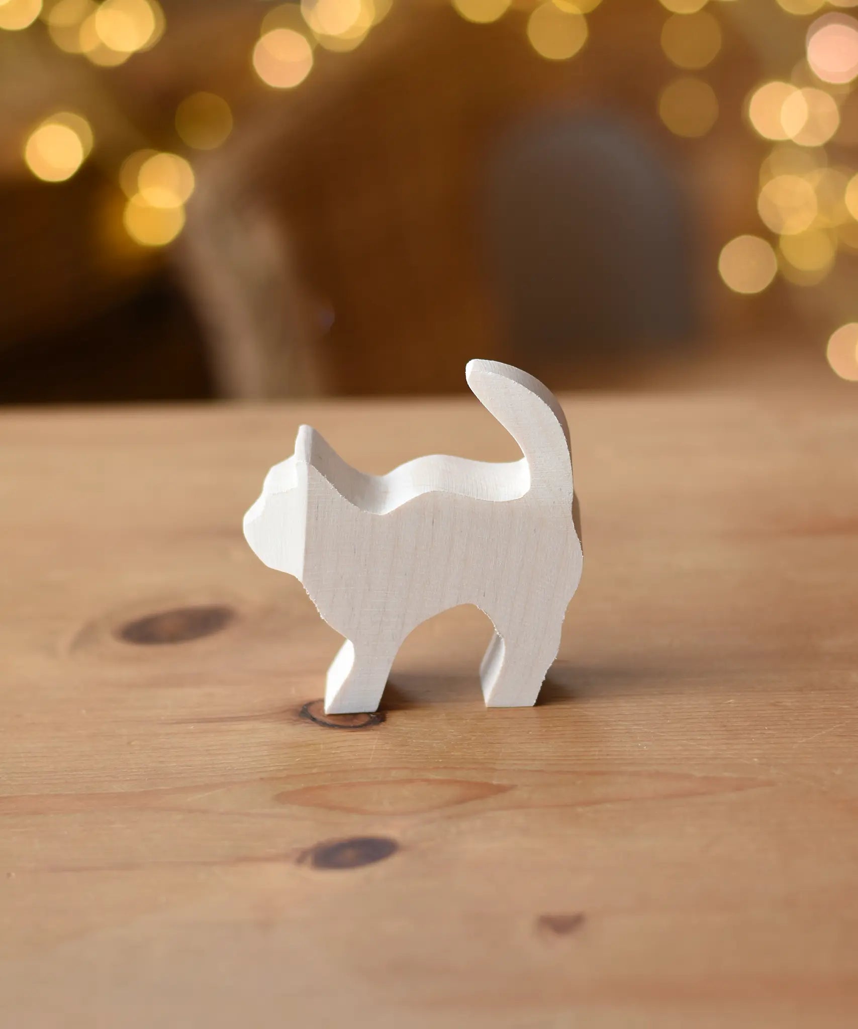 Ostheimer paint your own standing cat figure placed on a wooden surface.