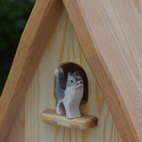 An Ostheimer wooden Waldorf style wooden toy figure placed on a perch on the fairy tale dolls house. These wooden figures are part of a large range of expertly hand crafted, Waldorf inspired, wooden toys here at Babipur.