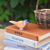An Ostheimer wooden chaffinch bird figure placed on a pile of old books.