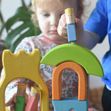 Ostheimer Rainbow Castle Blocksbeing played with by children, placing a blue king figure on top of a stack.