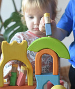Ostheimer Rainbow Castle Blocksbeing played with by children, placing a blue king figure on top of a stack.
