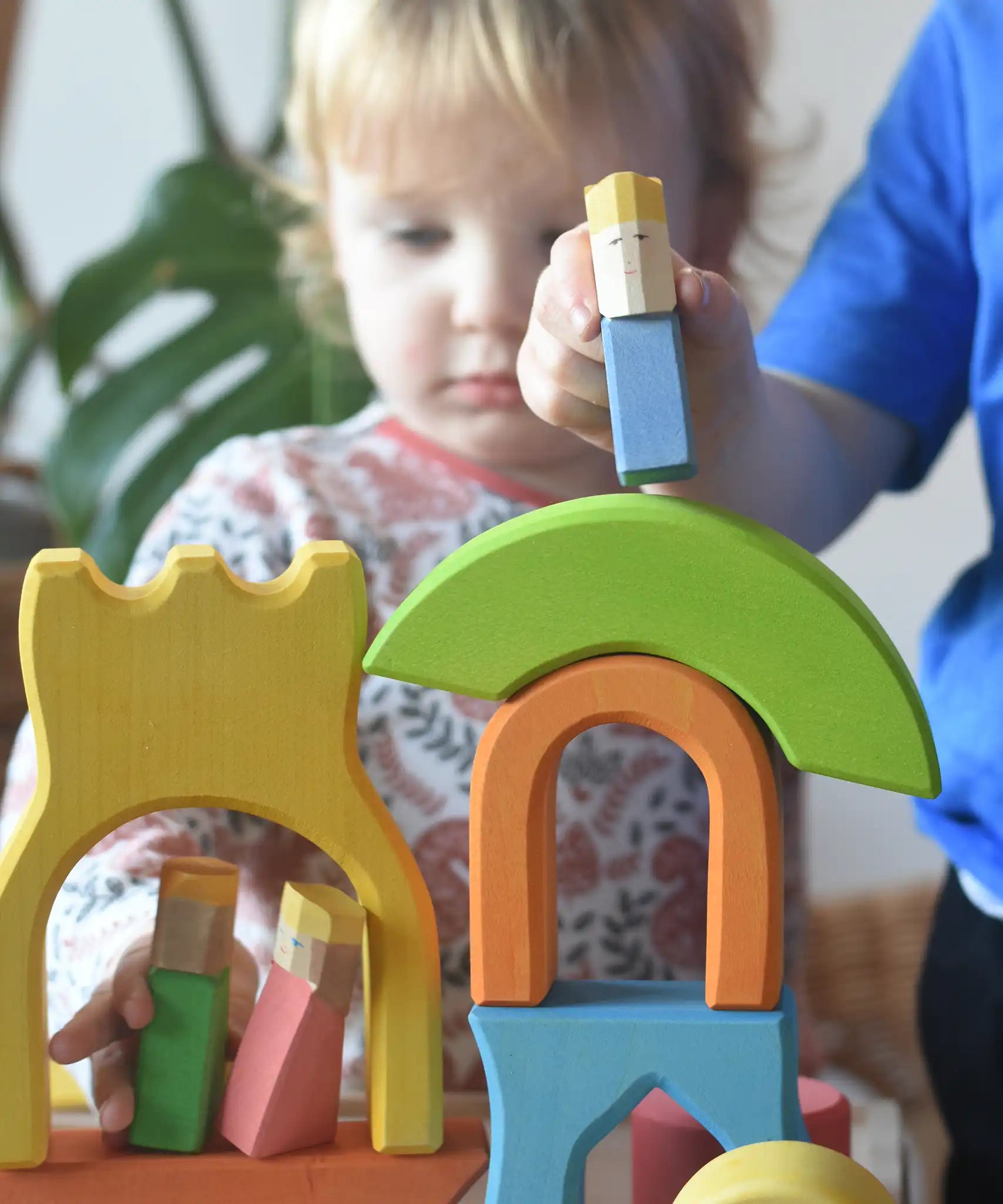 Ostheimer Rainbow Castle Blocksbeing played with by children, placing a blue king figure on top of a stack.