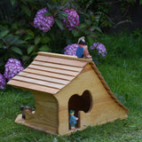 An Ostheimer wooden cottage dolls house with an sitting shepard figure placed on the roof. These wooden figures are part of a large range of expertly hand crafted, Waldorf inspired, wooden toys here at Babipur. 