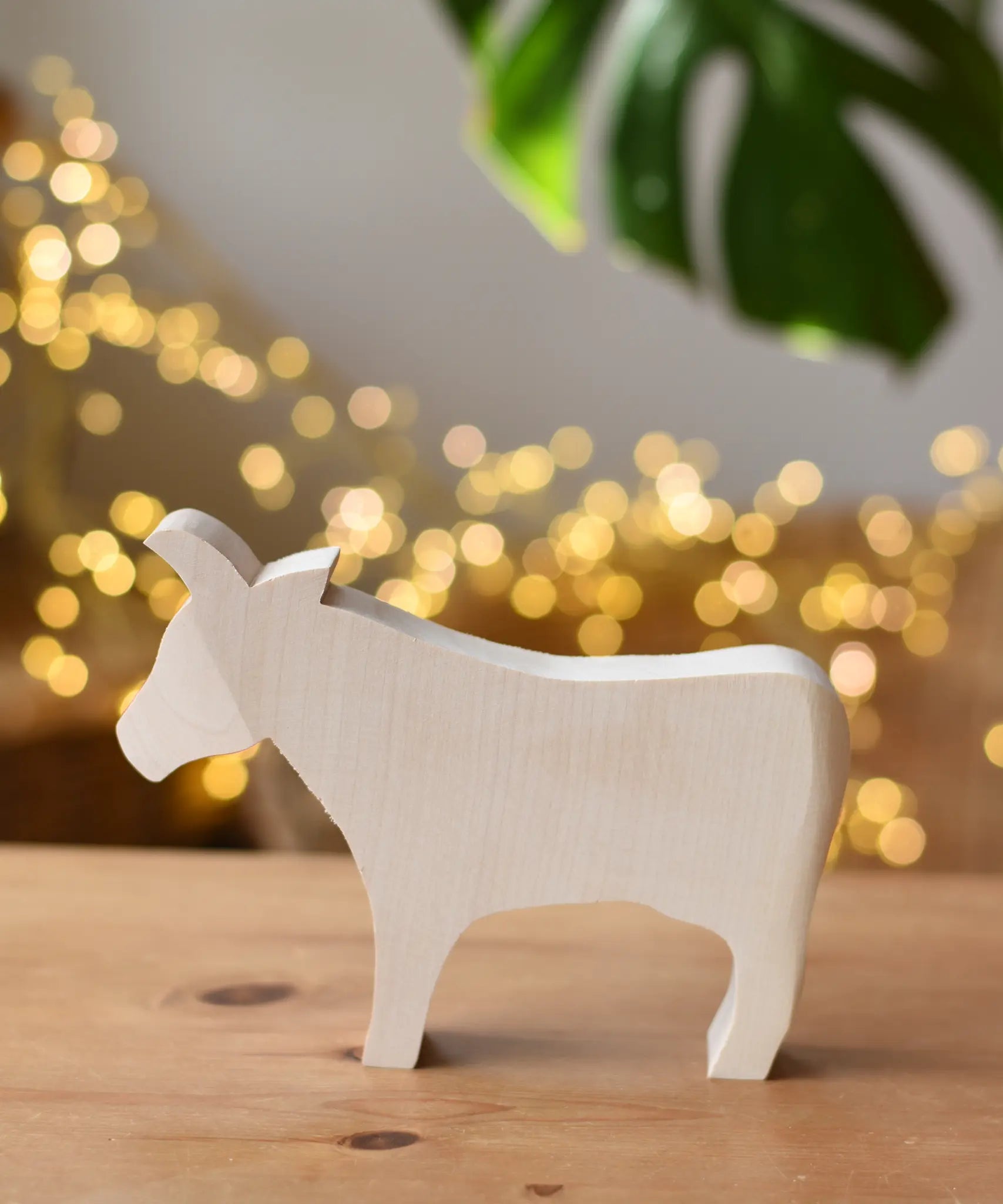 Ostheimer cow paint your own wooden figure placed on a wooden surface. 