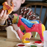 A child with the figures from the Ostheimer creative set in front of them. Some have been painted. 