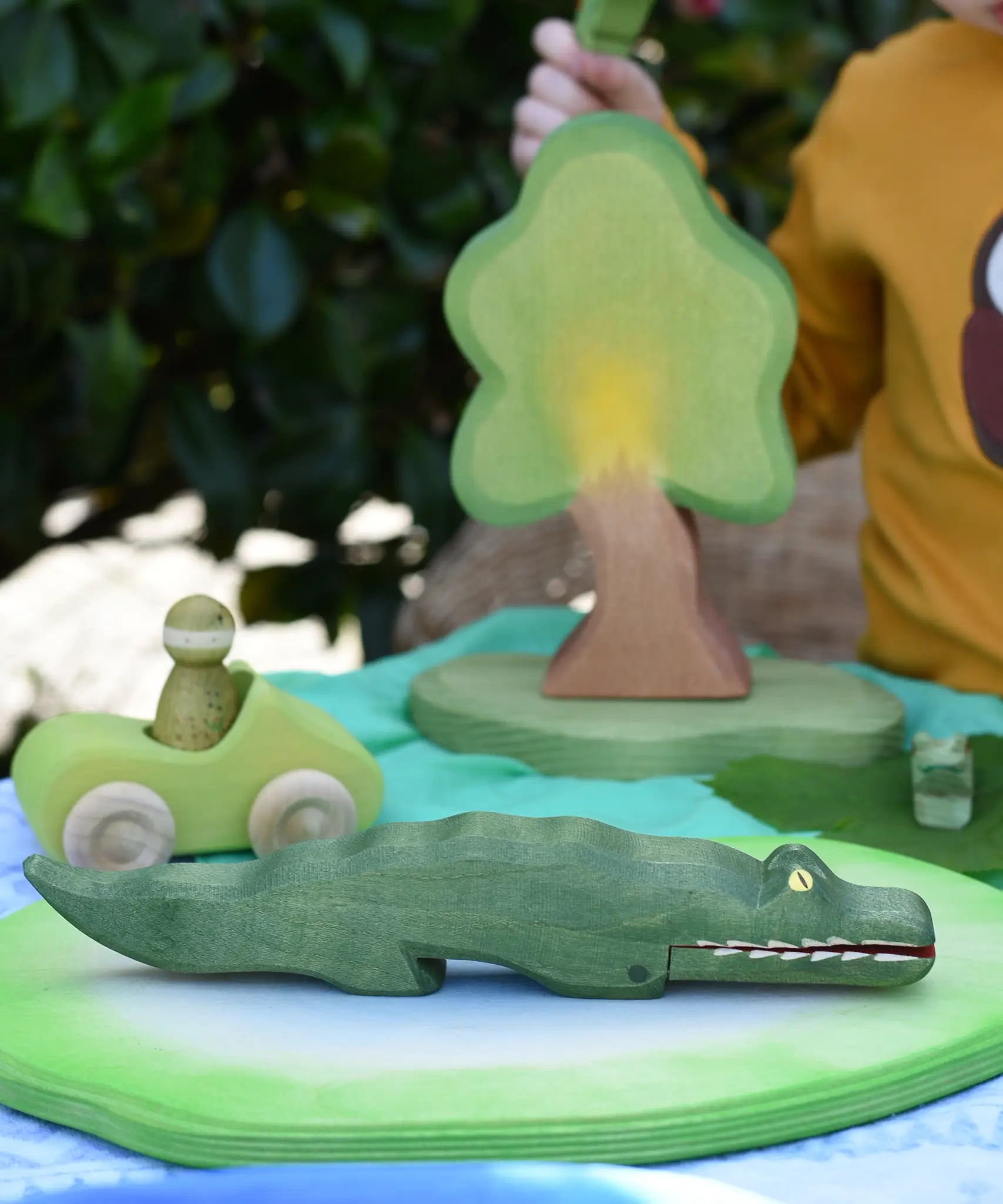 Ostheimer crocodile wooden toy figure placed on a pond piece in a small world play scene. 