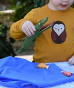 Ostheimer crocodile wooden toy figure with moveable jaw in a child's hand with it's mouth open. 