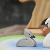 An Ostheimer grey coloured cygnet placed on a pond scene piece. 