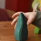 Child's hand reaching for the Ostheimer dark green bush toy scenery piece.