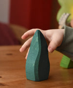 Child's hand reaching for the Ostheimer dark green bush toy scenery piece.