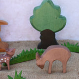 An Ostheimer eating deer wooden toy figure placed in a small world play scene with other fawn and deer and Ostheimer grass and an oak tree. Check out our full range of expertly crafted wooden toy figures and scenery here at Babipur.